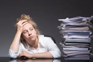 stressed girl looking at pile of books